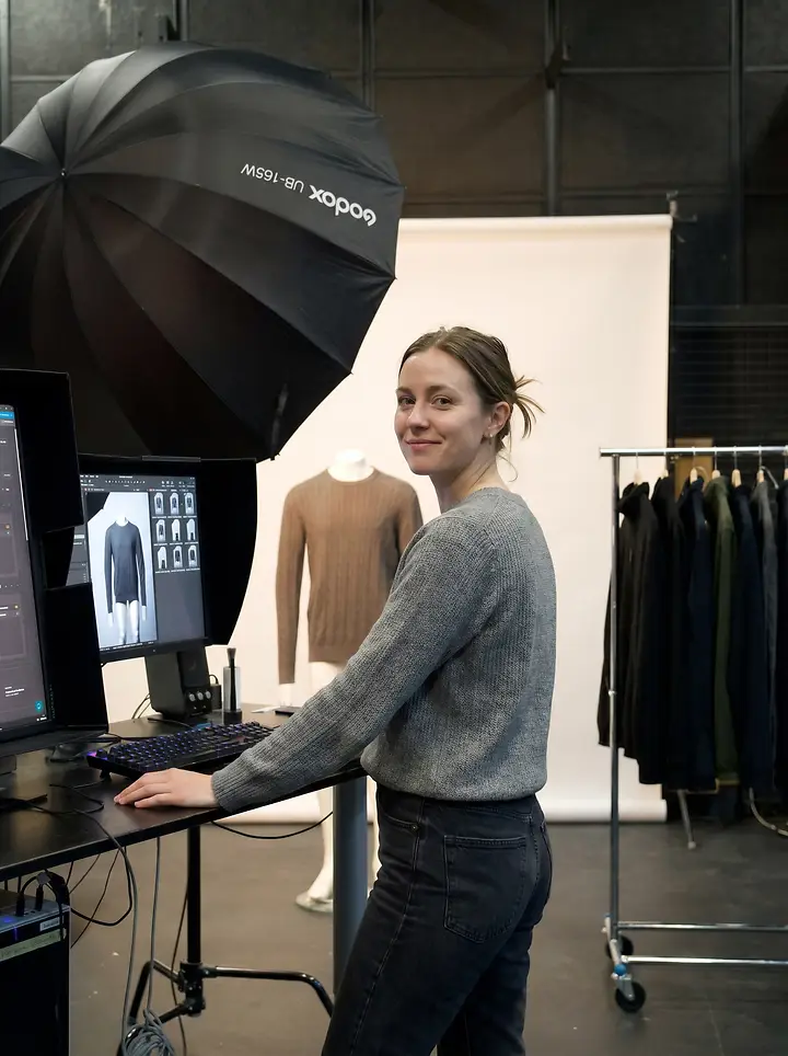 Photographer in a content studio at a tethered workstation in the middle of a product shoot.